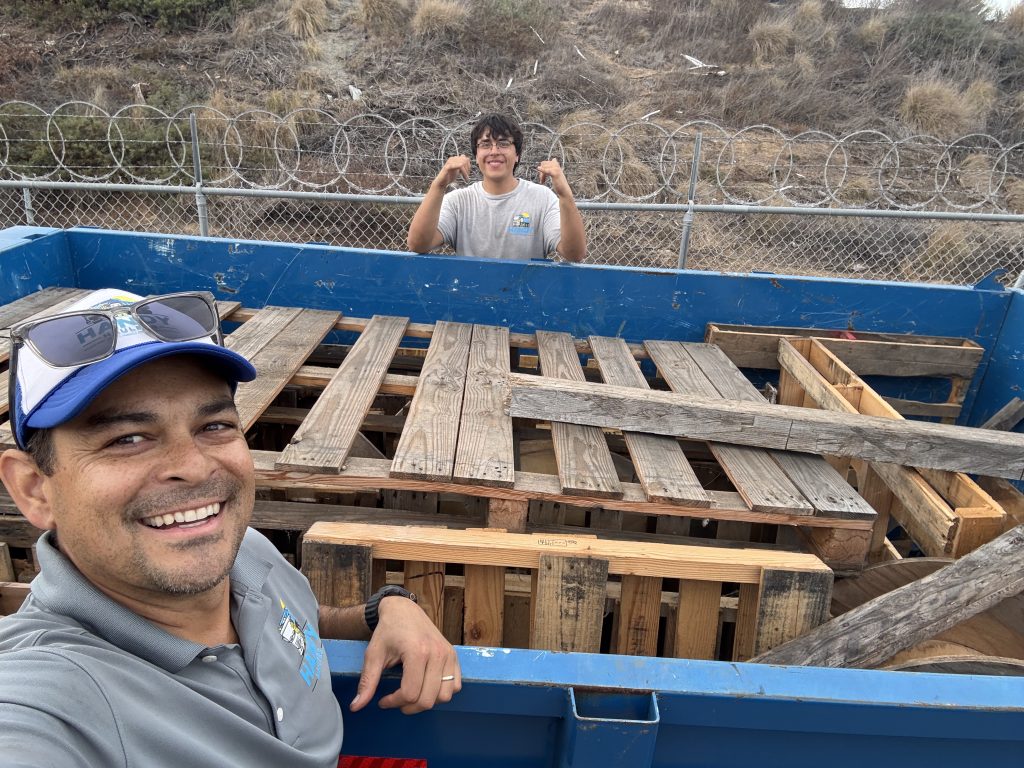 Handy Haulers team with a trailer full of pallets from a commercial haul-away job in San Diego.